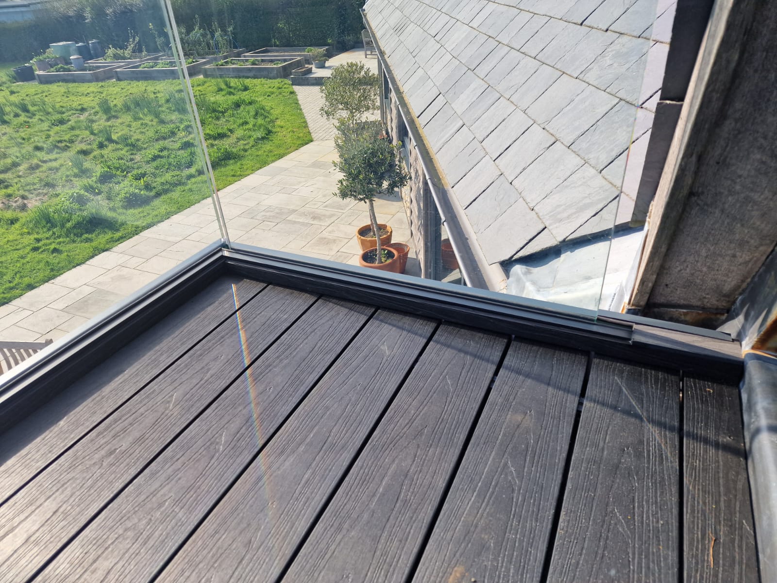 Fully Frameless Glass Balustrade installed for a private client in buxted, includes balcony facia covers in RAL7016 Showing decking by NeoTimber